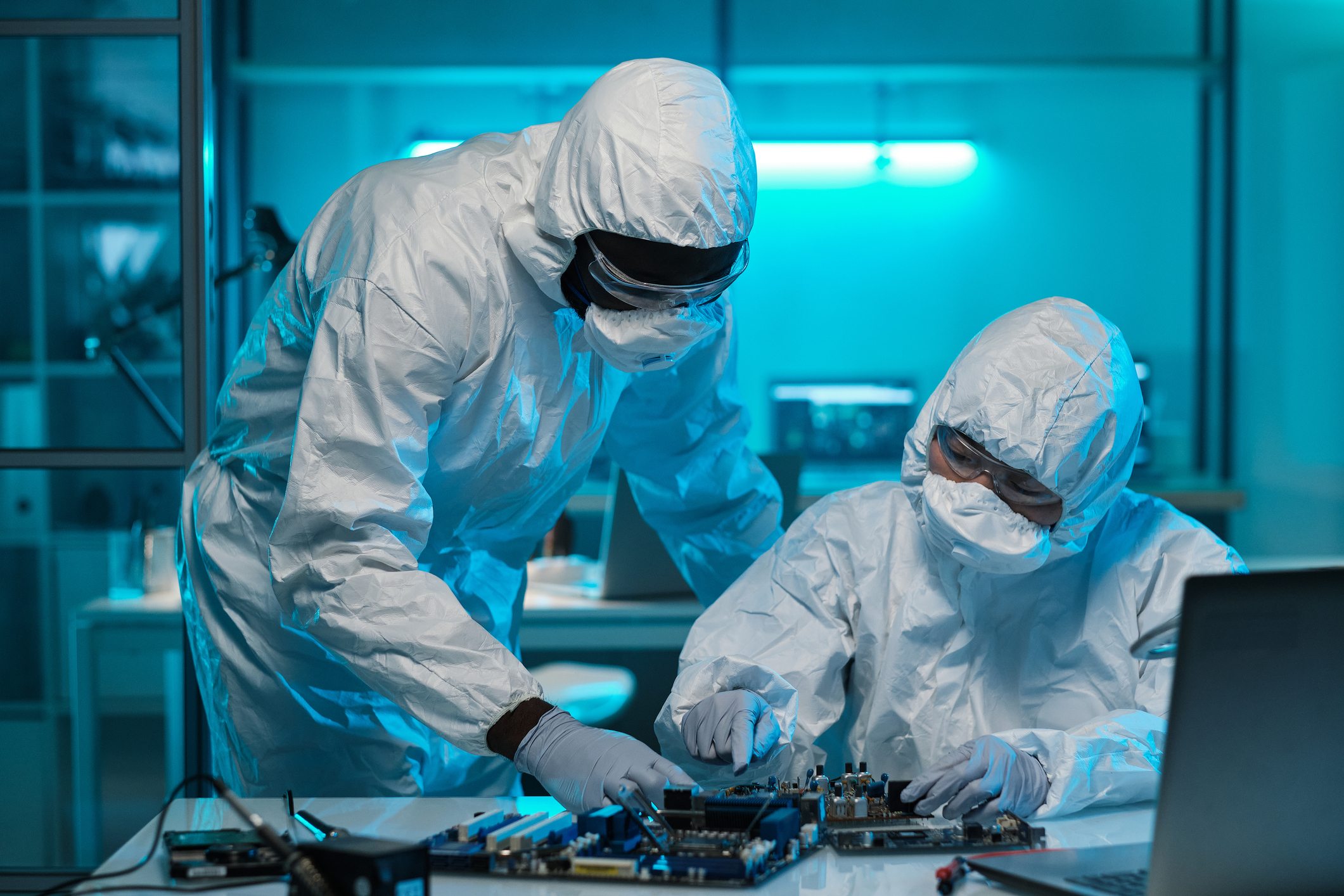 Scientists in protective suits working in lab.